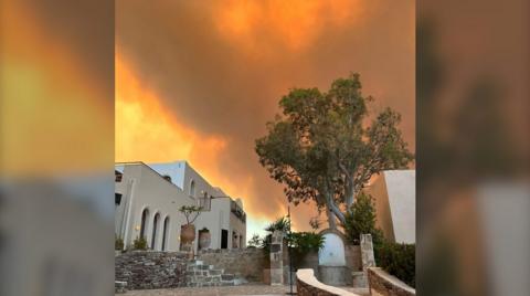 Fire burns and the sky glows orange above hotel in Rhodes