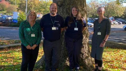 Four members of the Dog Warden service standing in front of a tree