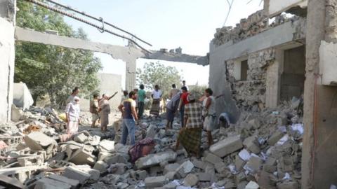 People stand on the rubble of a prison struck by Arab coalition warplanes in al-Zaydiyah district of the Red Sea port city of Hodeidah, Yemen October 30, 2016.