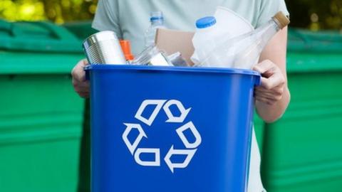 Person holding a plastic recycling bin