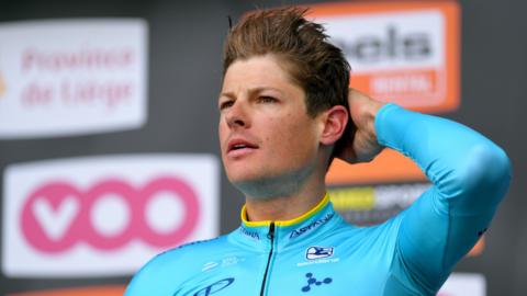 Astana rider Jakob Fuglsang runs his hand through his hair on the podium