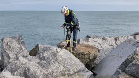 A member of the coastguard doing rope training