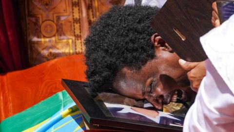 A mourner cries on the coffin of his loved one during a memorial service for the Ethiopian passengers and crew who perished in the Ethiopian Airways ET302 crash.