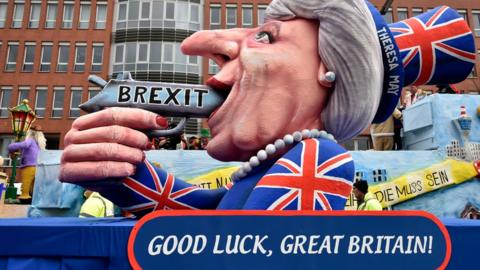 A carnival float depicts British Prime Minister Theresa May with a gun and the writing "Brexit" on it prior to the traditional carnival parade in Duesseldorf, Germany, on Monday, Feb. 27, 2017.