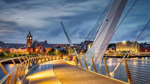 The peace bridge in Derry illuminated at dusk