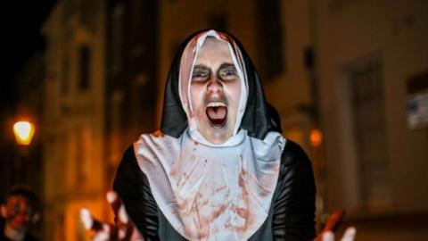 A man dressed as a nun screaming