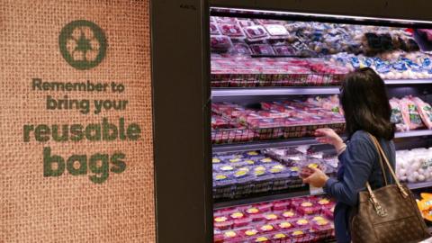 A shopper selects items inside a plastic bag-free Woolworths supermarket in Sydney, Australia, June 15, 2018.