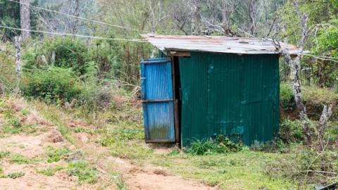 a corrugated tin outhouse