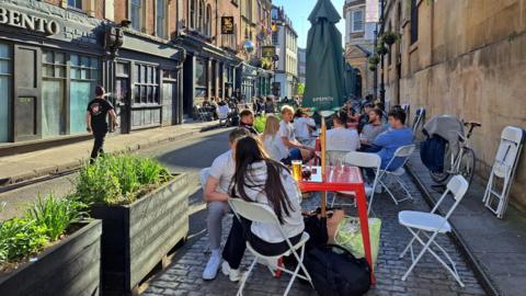 Outdoor diners and drinkers at tables on St Nicholas Street in Bristol