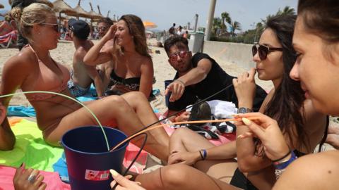 Tourists lounge on the beach at the Ballermann stretch on 26 July 2017