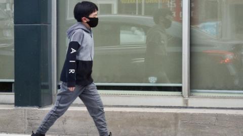 Boy wearing a face mask to protect him from the novel coronavirus (COVID-19) while walking in Toronto, Ontario, Canada on May 31, 2020