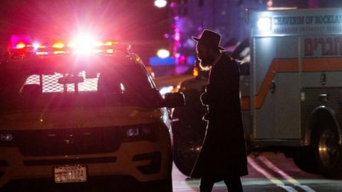 A Jewish man walks near the area where 5 people were stabbed at a Hasidic rabbi"s home in Monsey