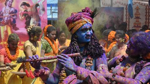 Youths smeared in coloured powder and dressed as Lord Krishna and deity Radha celebrate the Holi festival, the Hindu spring festival of colours, in Kolkata, India.