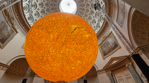 Illuminated sun sculpture hung up inside Kedleston Hall
