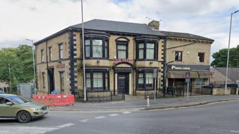 A large two-storey pub with the name "Venue" over the front door in red lettering.