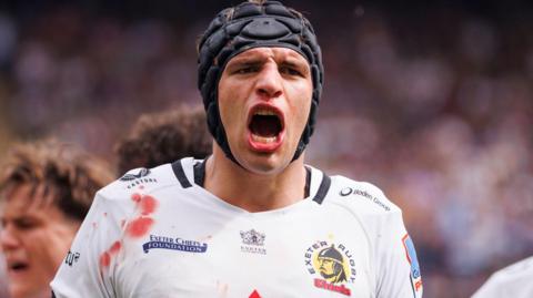 Dafydd Jenkins, wearing a white Exeter Chiefs shirt, shouts