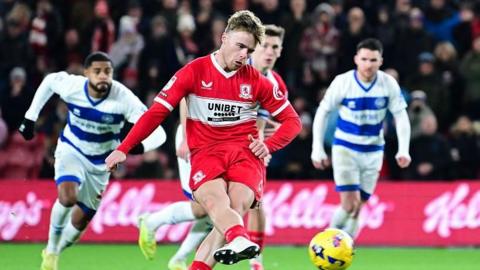 Tommy Conway strokes his penalty with his right foot as three QPR players look on behind him