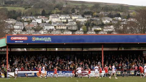 A photo of Cougar Park during a match against the backdrop of Keighley. Pictured in the background are rows of houses on a hill