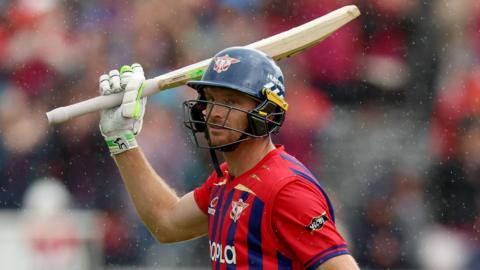 Jos Buttler wearing a helmet and raising his bat while playing for Manchester Super Giants