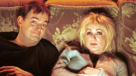 Actor Craig Cash sat on a crushed velvet sofa next to Caroline Aherne on the set of the Royle Family. 