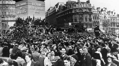 VE Day Celebrations on 8 May 1945. A general view of the tremendous scene in Trafalgar Square, full of people and a poster over a column saying 'Victory over Germany 1945'.