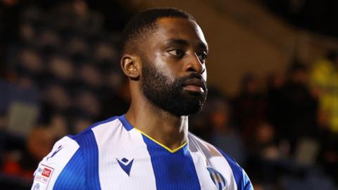 Kane Vincent-Young in a blue and white striped Colchester United home jersey before a match.