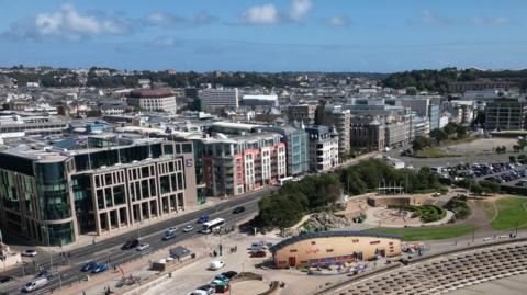 An aerial view of buildings in St Helier and a main road in front of it.