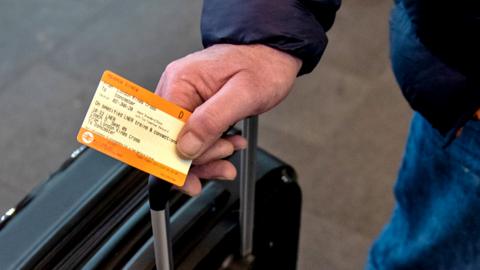 Person holding a train ticket