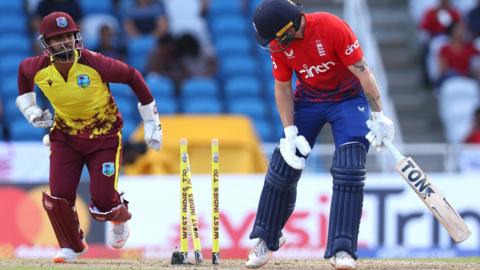 England batter Phil Salt is bowled, with West Indies wicketkeeper Nicholas Pooran celebrating behind him