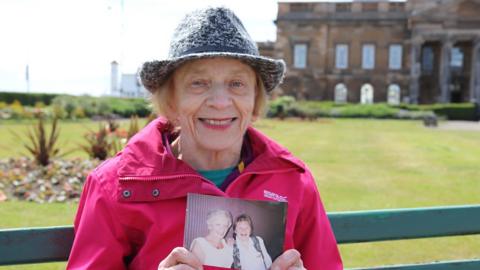 Margaret holding a photograph of her daughter