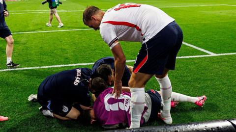 Dan Burn of England (R) tries to help his teammate Jordan Henderson who was injured amid the celebrations