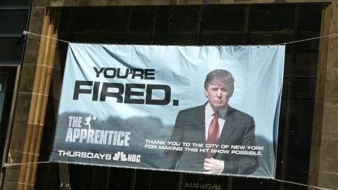 A sign advertising the television show 'The Apprentice' hangs at Trump Towers April 15, 2004 in New York City
