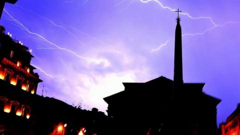 Lightning flashes across the sky over the Pantheon monument during a hailstorm in downtown Rome