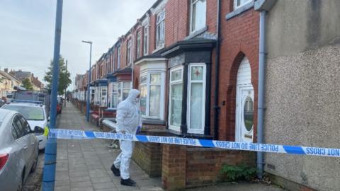 A forensic officer entering the property