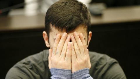 Ali Bashar covers his face as he arrives for the beginning of his trial at a courtroom of the regional court in Wiesbaden, Germany, 12 March 2019