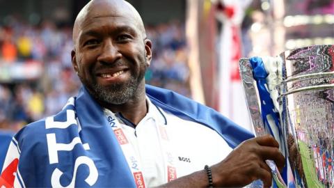 Darren Moore holds the trophy after winning promotion to the Championship with Sheffield Wednesday