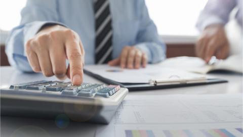 Man punching numbers into calculator