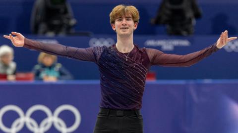 Ed Appleby, with arms outstretched, competing in the figure skating team competition at the 2026 Winter Olympics