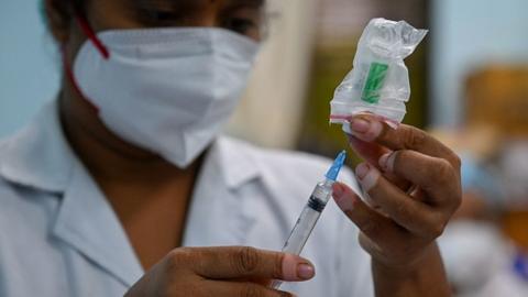 A health worker prepares a dose of the Covishield vaccine