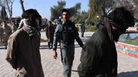 Members of the Afghan security services escort two of six alleged members of the group calling themselves the Islamic State (IS), arrested after clashes with Afghan security forces in the Bahsood district of Nangarhar province, Afghanistan, 20 January 2016.