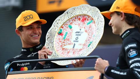 Lando Norris smiling with McLaren team-mate Oscar Piastri