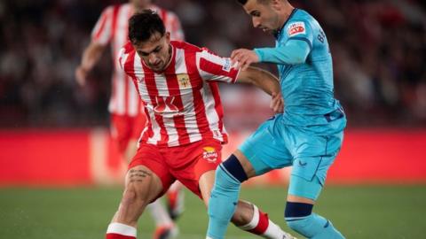Almeria midfielder battles for the ball