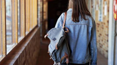 Girl walking down a school corridor