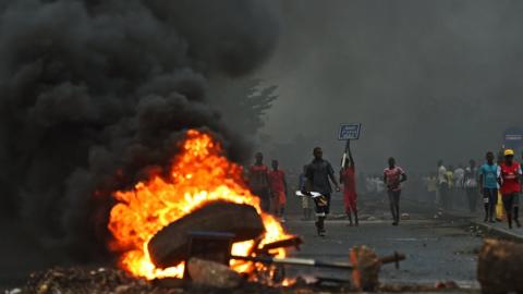 Protestors opposed to the Burundian president Pierre Nkurunziza"s third term in office gather by a burning barricade during a demonstration in the Cibitoke neighborhood of Bujumbura on May 19, 2015.