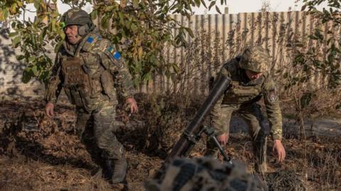 Ukrainian forces fire a mortar over the Dnipro River toward Russian positions