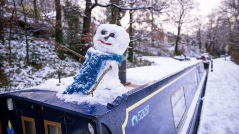 A snowman sits a canal boat in Llangollen