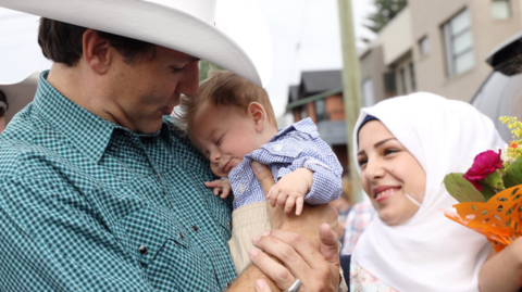 Canada PM Justin Trudeau (left) holds Justin Trudeau Adam Bilal