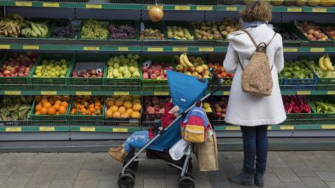 Mother and child buy fruit at the supermarket