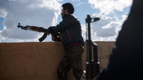 Syrian Democratic Forces member stands guard in Baghuz, February 2019