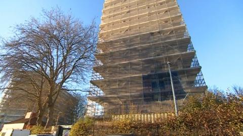 A tower block covered in scaffolding